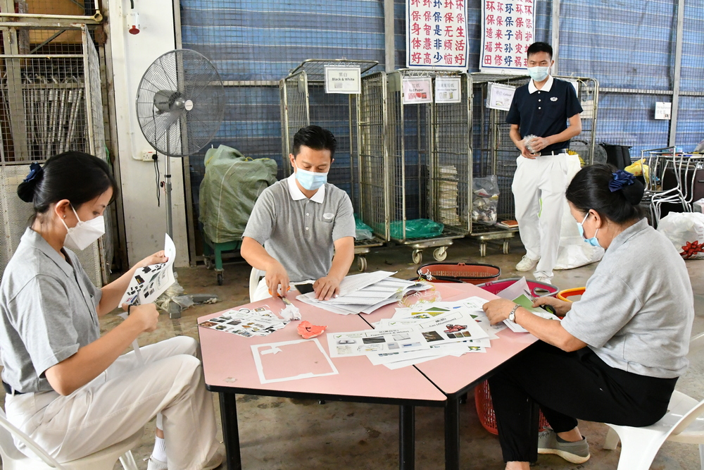 Volunteers gathering together to sort paper recyclables at the recycling zone. (Photo by Lin Suan Chu)