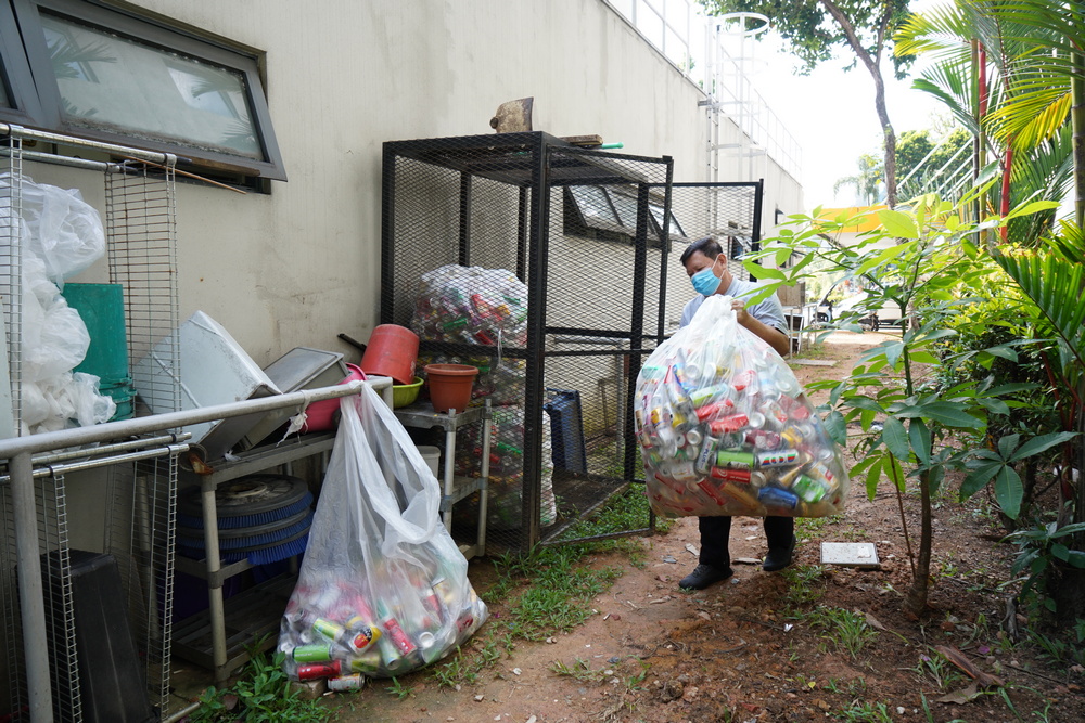 Mr Feng Theam Fook collecting bags of used aluminium cans. (Photo by Chan May Ching)