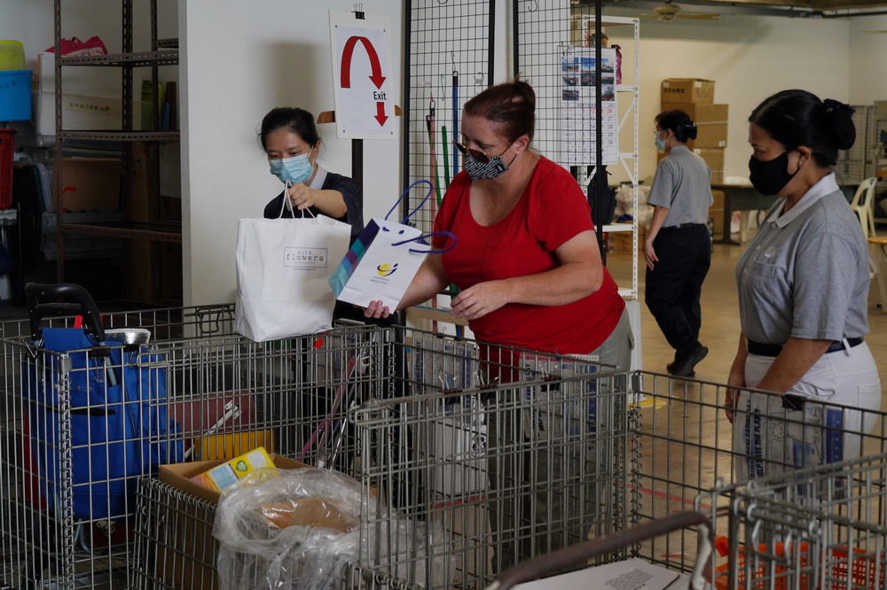 Volunteers guiding a member of the public on where to place the recyclables she brought. (Photo by Lin Chun Hwey)